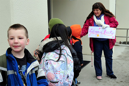 A school counselor welcomes students back for the school year.